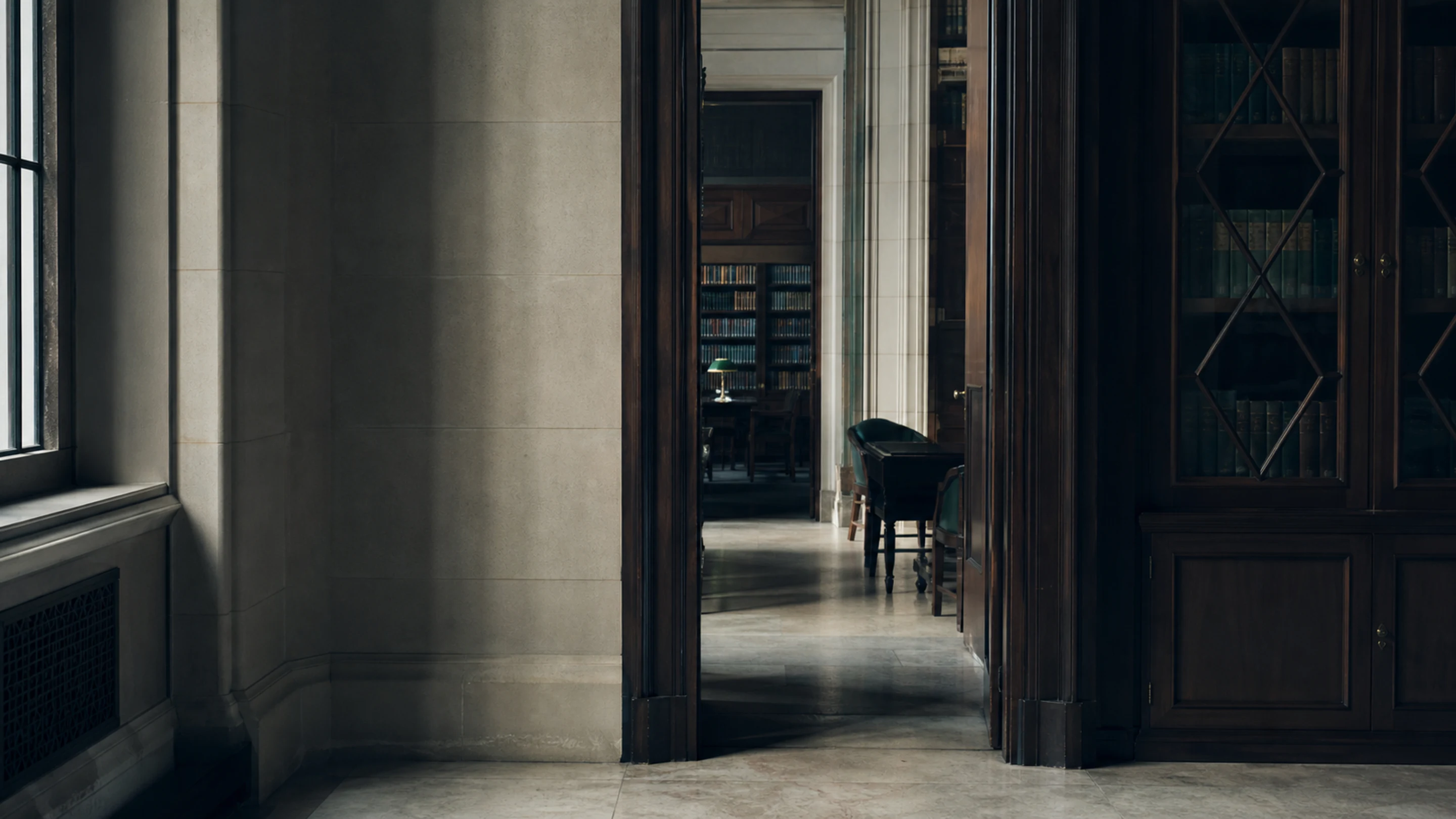 A panelled boardroom with a long leather-chaired table, a brass lamp, and the Manhattan skyline through tall windows